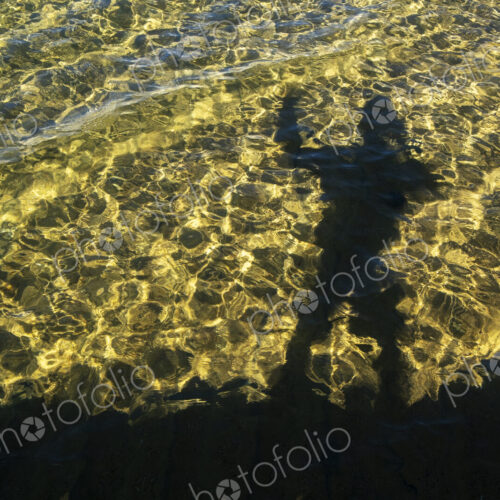 Shadow of photographer on the water surface of Lake Tahoe