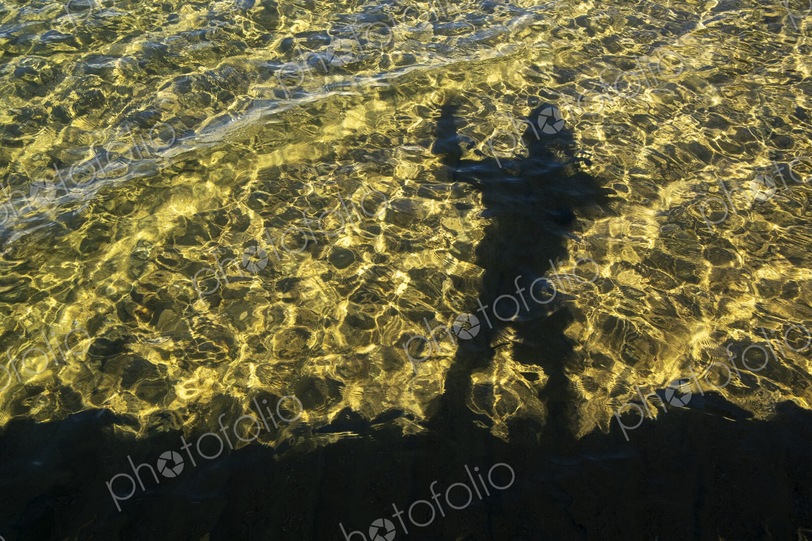 Shadow of photographer on the water surface of Lake Tahoe