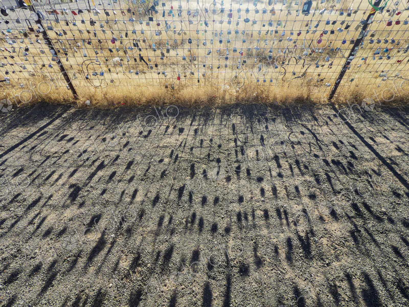 Shadows of Love Locks on a Farm Fence