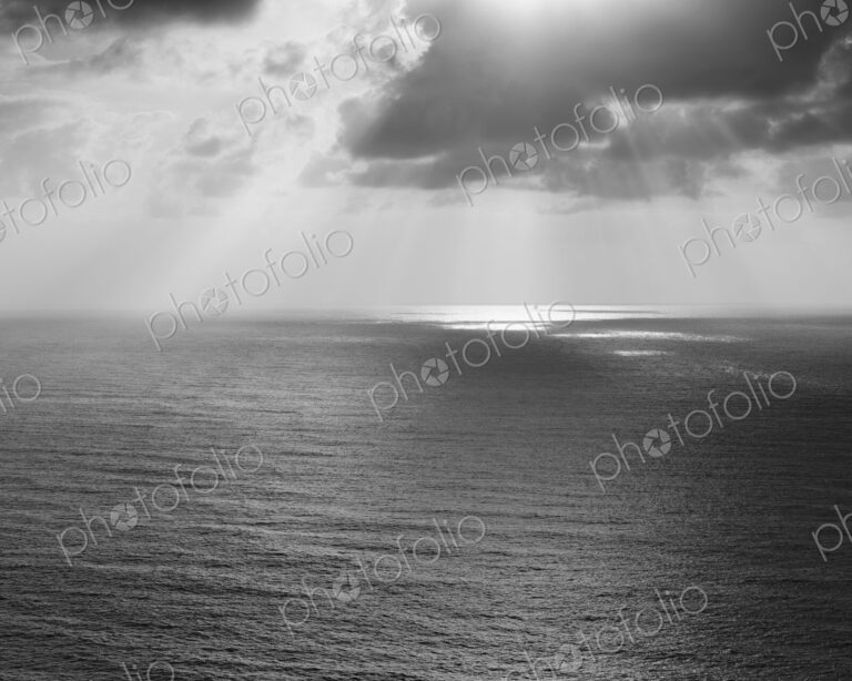 Shafts of sunlight shining through cloud and a view over the Pacific Ocean, at…