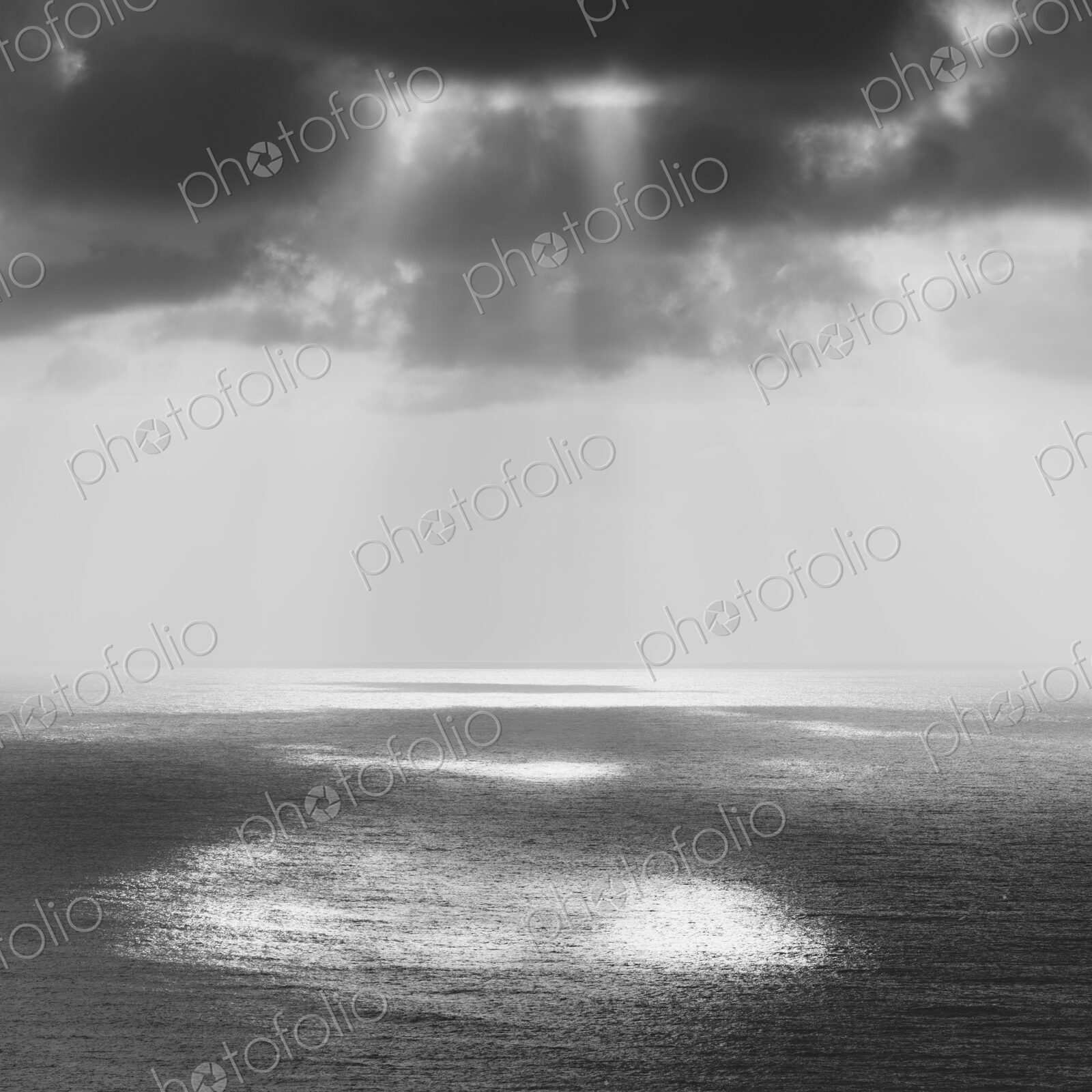 Shafts of sunlight shining through cloud and a view over the Pacific Ocean, at…