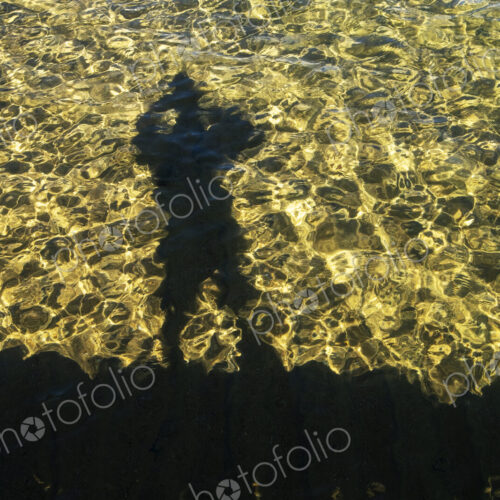 Shaodw of photographer on clear waters of Lake Tahoe, High Sierra, CA, USA