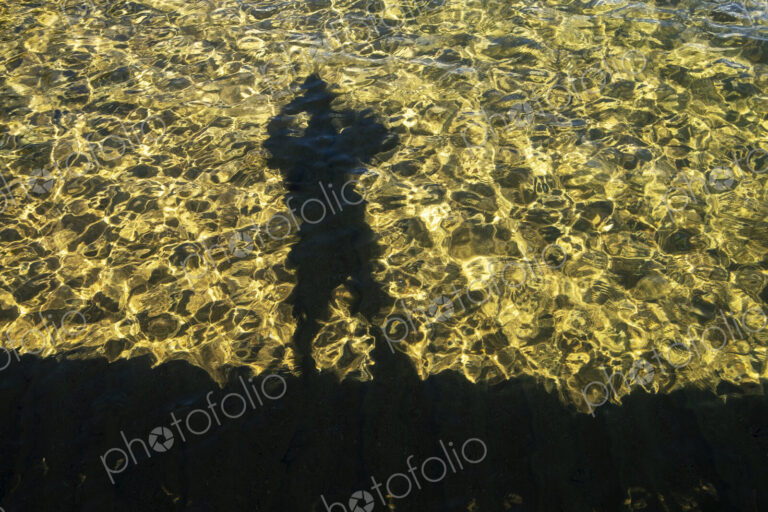 Shaodw of photographer on clear waters of Lake Tahoe, High Sierra, CA, USA