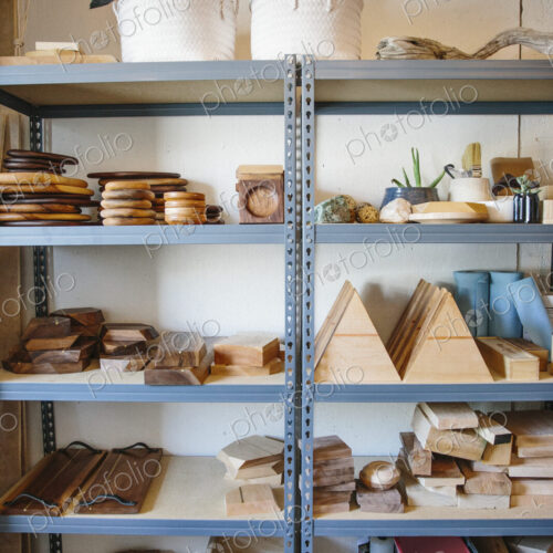 Shelves in a wood turner's workshop and a display of smooth wooden blocks and bowls.