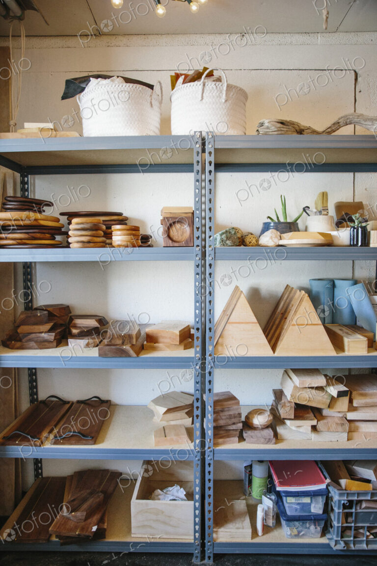 Shelves in a wood turner's workshop and a display of smooth wooden blocks and bowls.