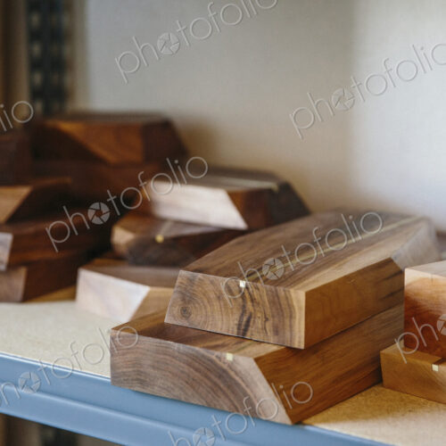 Shelves in a wood turner's workshop and a display of smooth wooden boards.
