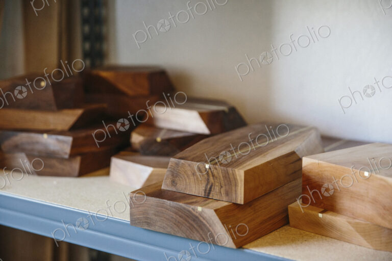 Shelves in a wood turner's workshop and a display of smooth wooden boards.