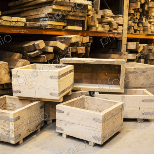 Shelves with wooden planks and a stack of wooden crates in a warehouse.
