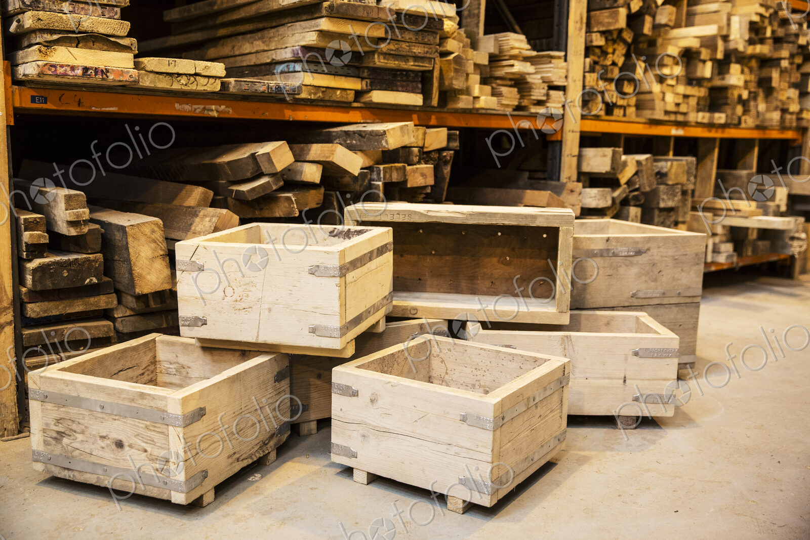 Shelves with wooden planks and a stack of wooden crates in a warehouse.