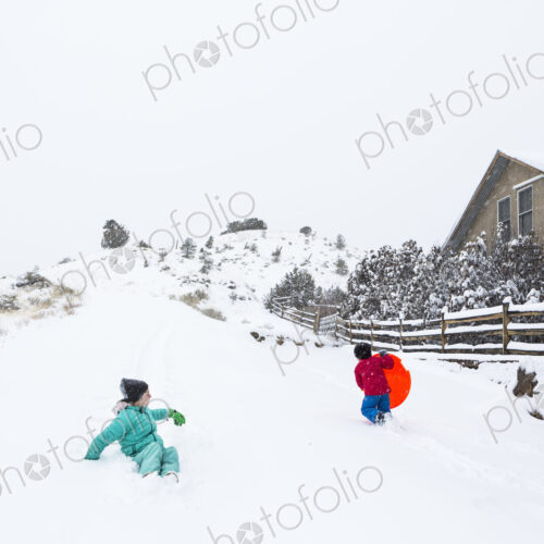 Siblings sledding down hill Siblings sledding down hill