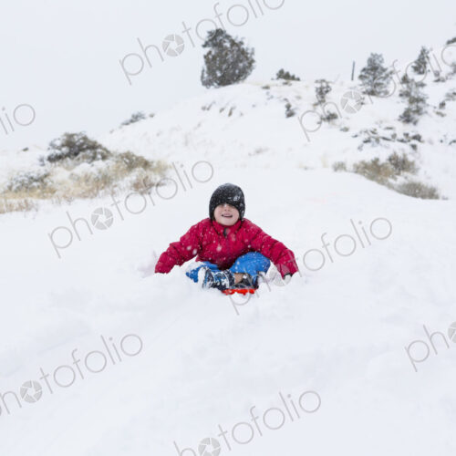 Siblings sledding down hill Siblings sledding down hill