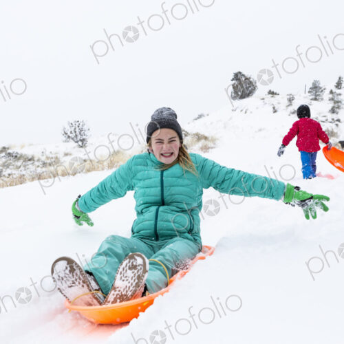 Siblings sledding down hill Siblings sledding down hill