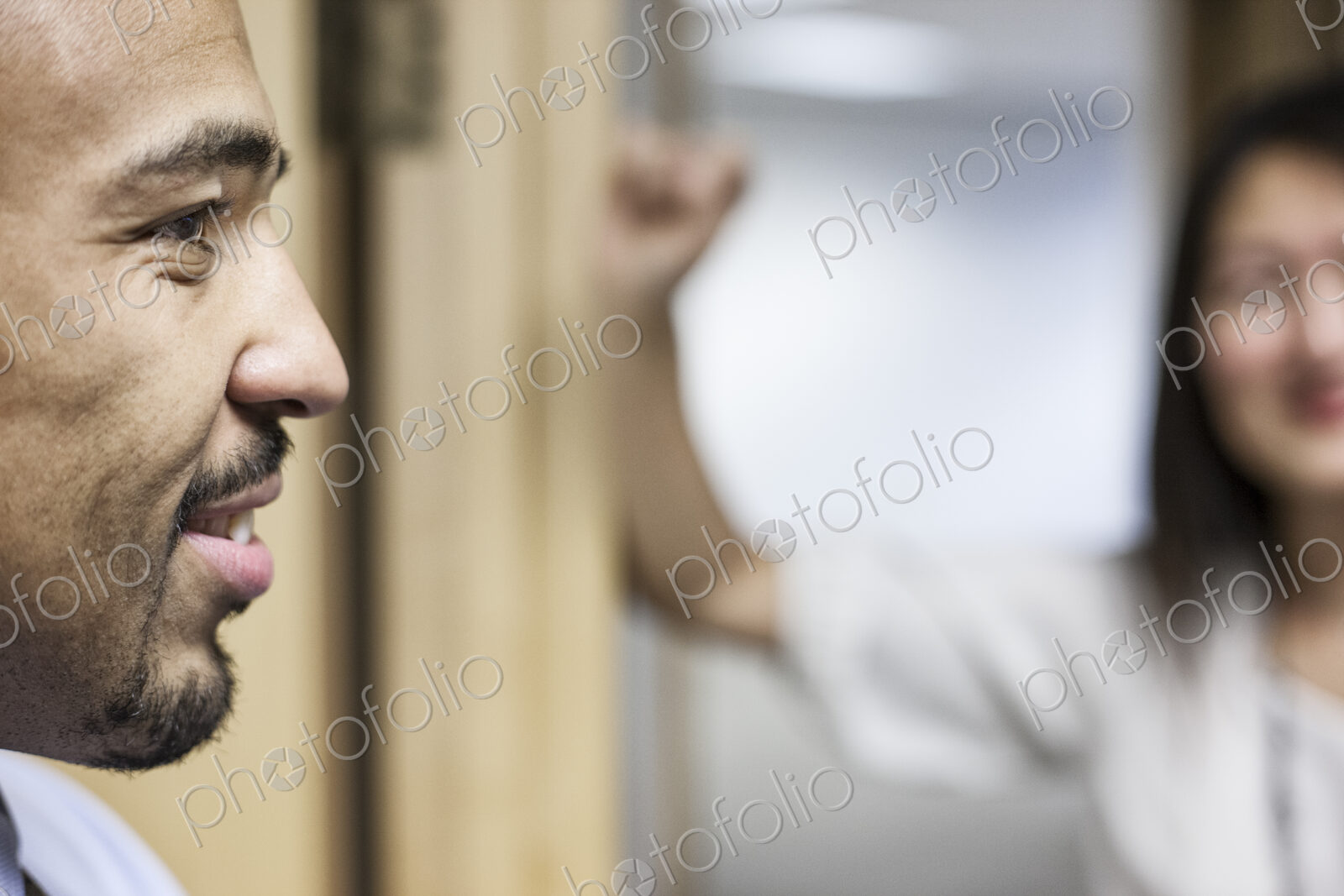 Side view closeup of a black businessman standing and talking in his office space.