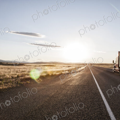 Side view of a trailer and truck on the road at sunset in eastern Washington, USA