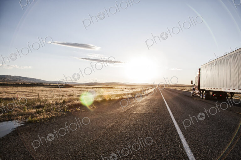Side view of a trailer and truck on the road at sunset in eastern Washington, USA