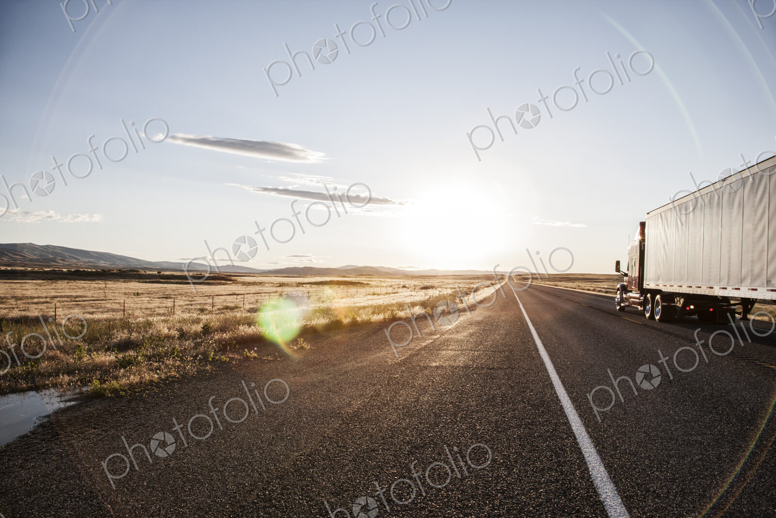 Side view of a trailer and truck on the road at sunset in eastern Washington, USA