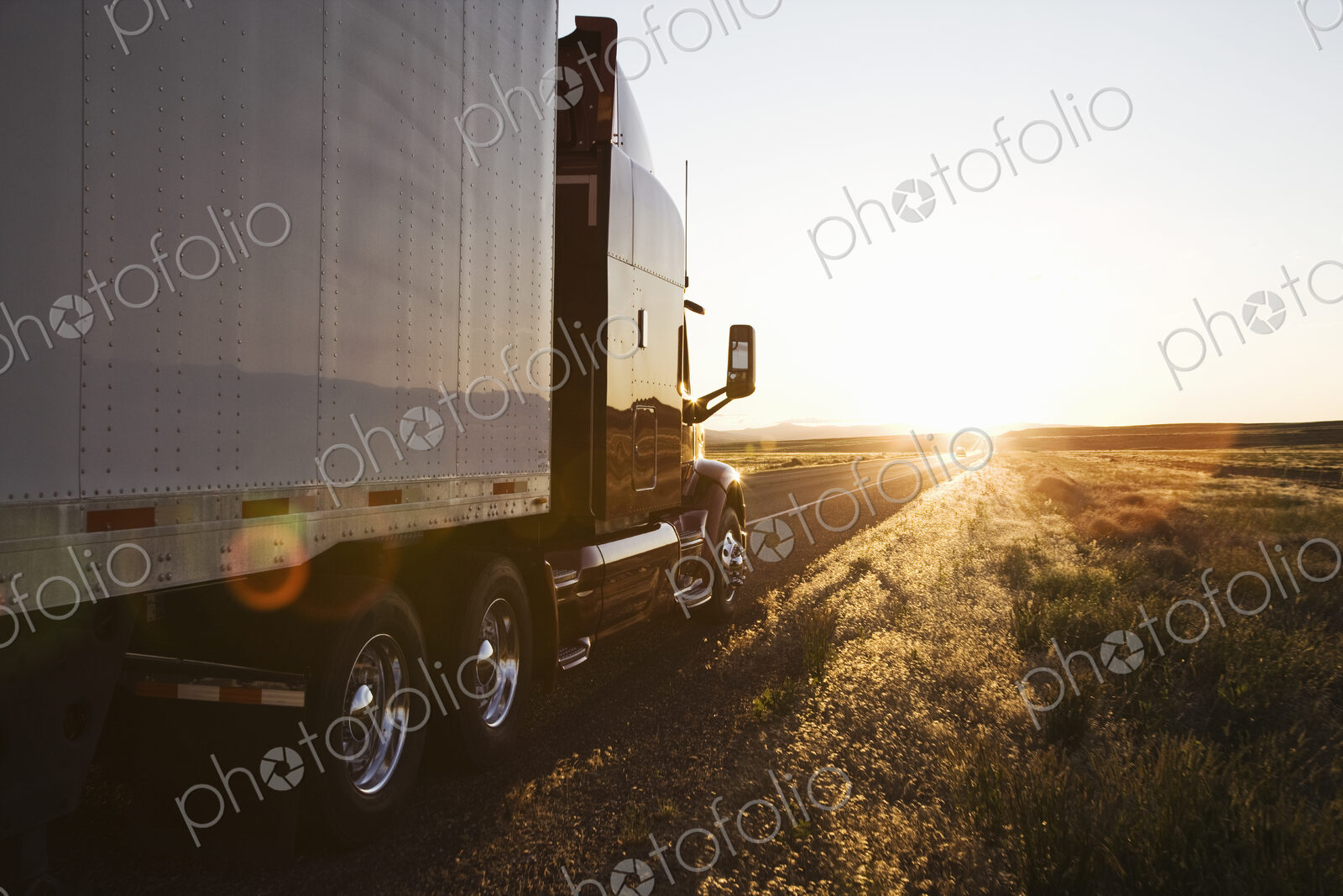 Side view of a trailer and truck on the road at sunset in eastern Washington, USA