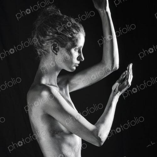 Side view of nude Caucasian woman with silver body paint Side view of nude Caucasian woman with silver body paint