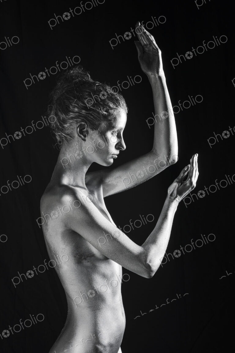 Side view of nude Caucasian woman with silver body paint