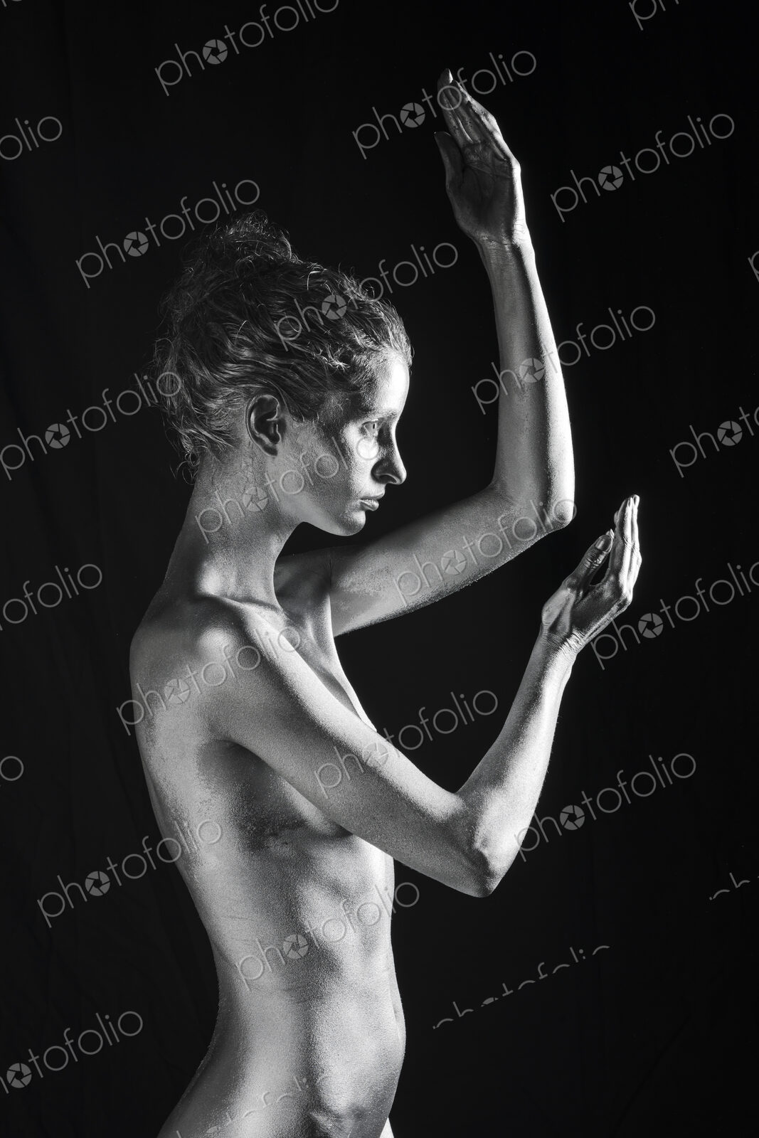 Side view of nude Caucasian woman with silver body paint