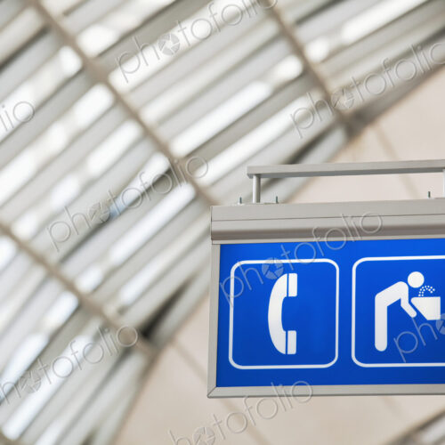 Sign for telephone and drinking fountain in large public building.