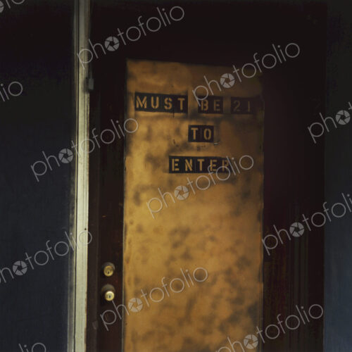 Sign on a door, Must Be 21 To Enter. An age requirement