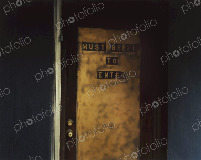 Sign on a door, Must Be 21 To Enter. An age requirement