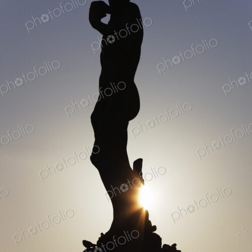 Silhouette of classical statue with setting sun behind. Silhouette of classical statue with setting sun behind.