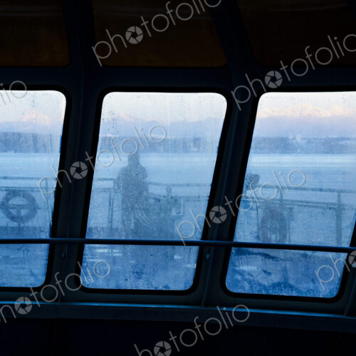 Silhouette of person through foggy window on Puget Sound ferry, WA USA