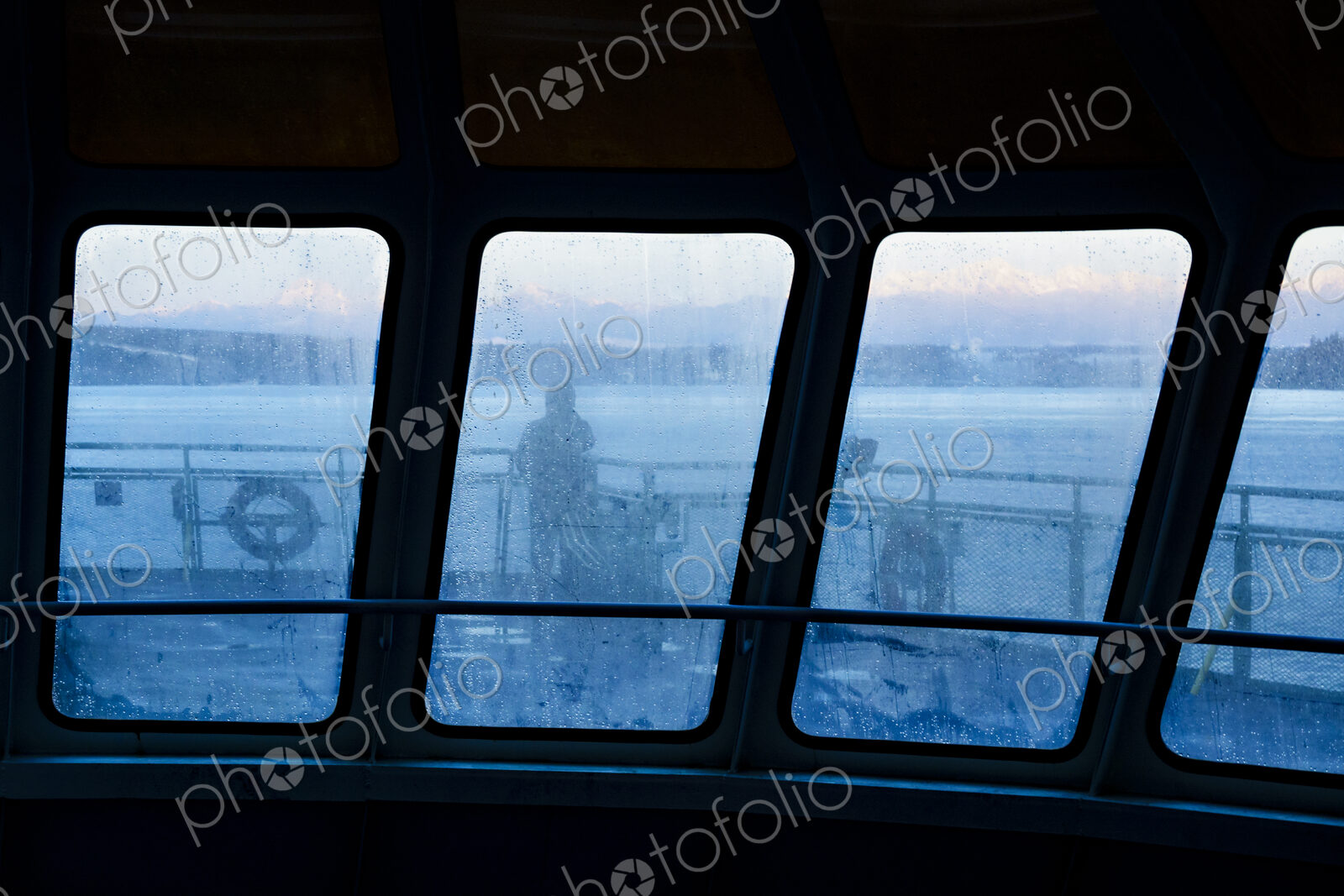 Silhouette of person through foggy window on Puget Sound ferry, WA USA