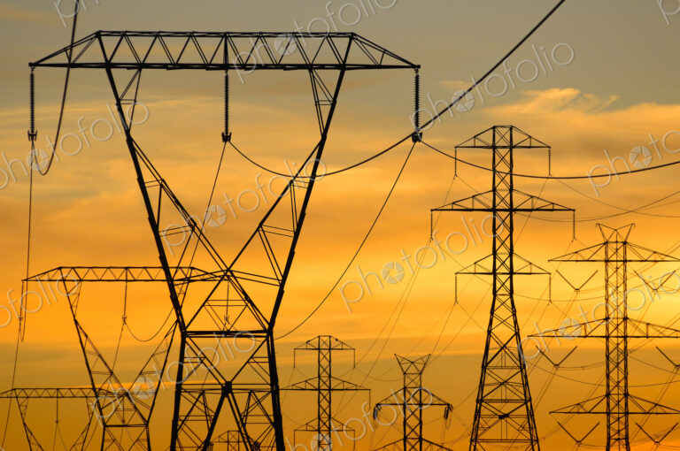 Silhouette of power lines under sunset sky