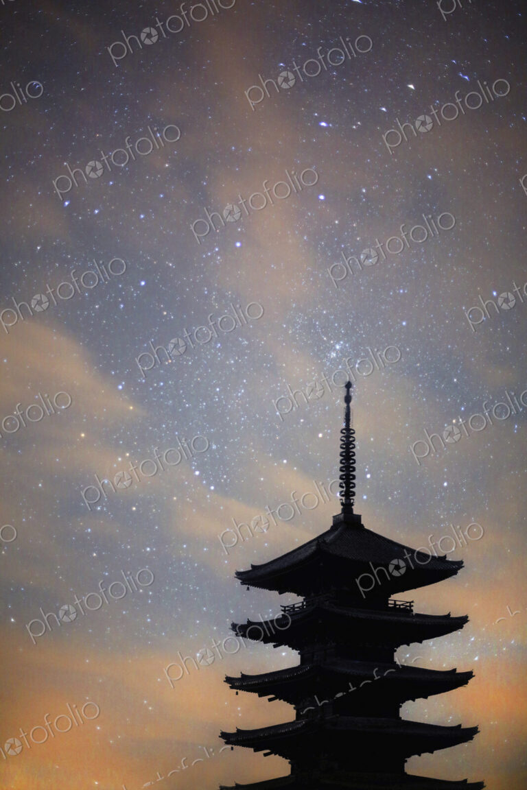 Silhouette of tall wooden pagoda of Buddhist temple against evening sky.