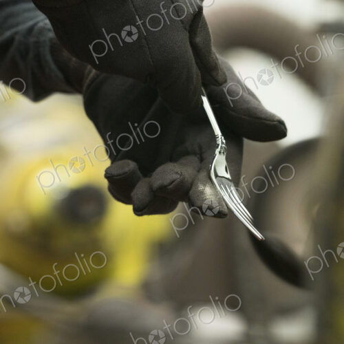 Silversmith polishing silver fork. Silversmith polishing silver fork.