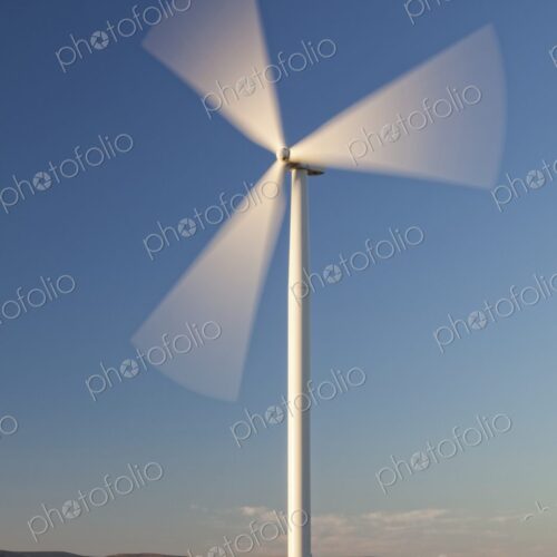 Single wind turbine spins in an open Oregon field beneath a clear blue sky,… Single wind turbine spins in an open Oregon field beneath a clear blue sky,…