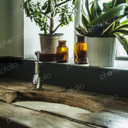 Sink in wooden counter with potted plants in window Sink in wooden counter with potted plants in window