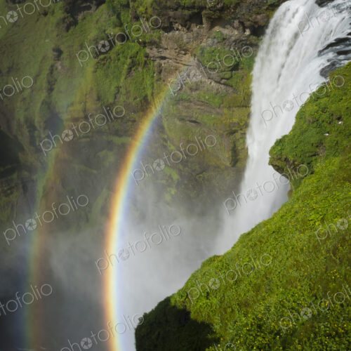 Skogafoss waterfall with a double rainbow in the mist and vapour rising from the water. Skogafoss waterfall with a double rainbow in the mist and vapour rising from the water.