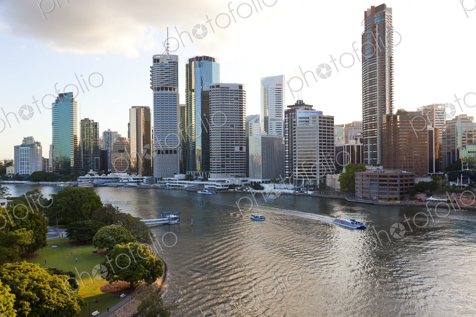 Skyline of city by the ocean, with skyscrapers and boats on the river.