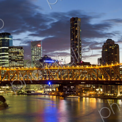 Skyline of city, with illuminated skyscrapers and bridge over river in the foreground. Skyline of city, with illuminated skyscrapers and bridge over river in the foreground.