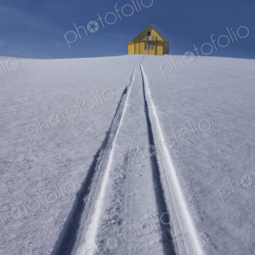 Sled tracks on hillside to yellow rural house in Estonia. Sled tracks on hillside to yellow rural house in Estonia.