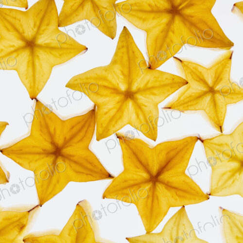 Slices of organic starfruit on a white background