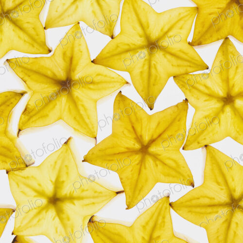 Slices of organic starfruit on white background