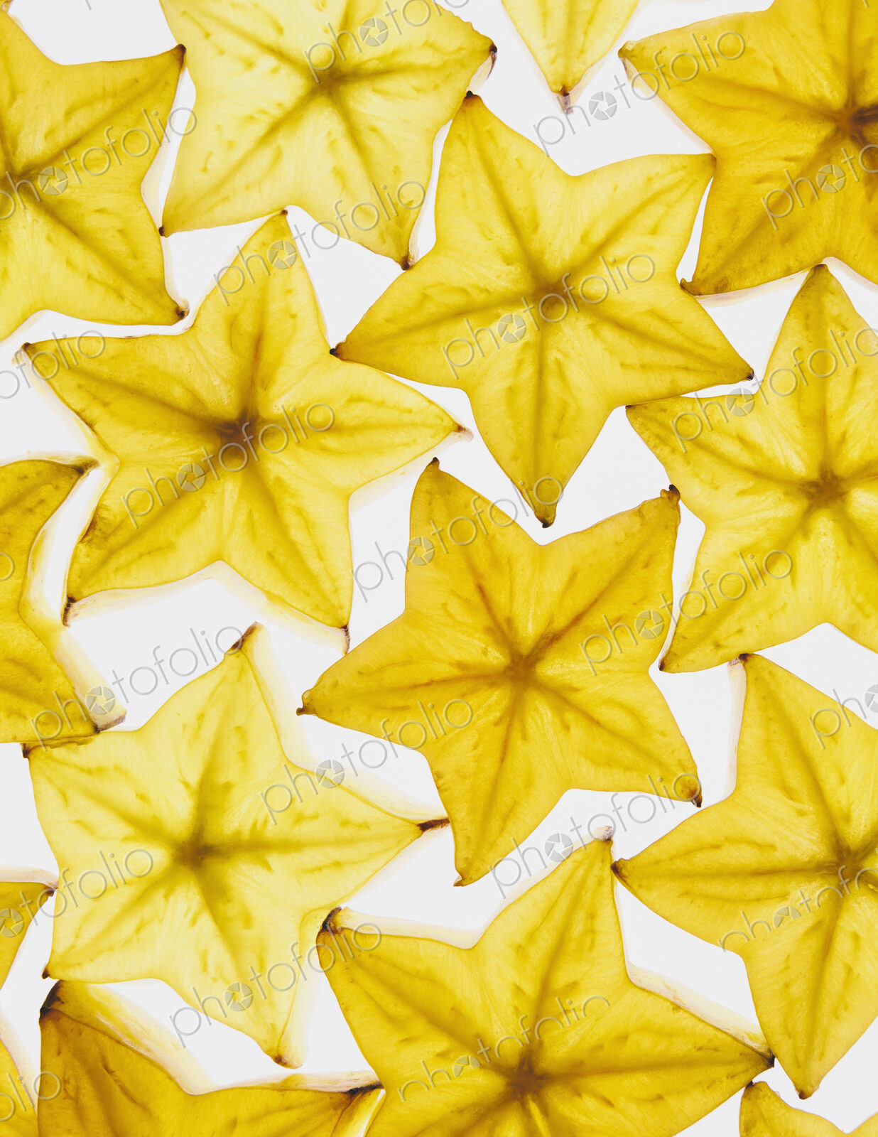 Slices of organic starfruit on white background