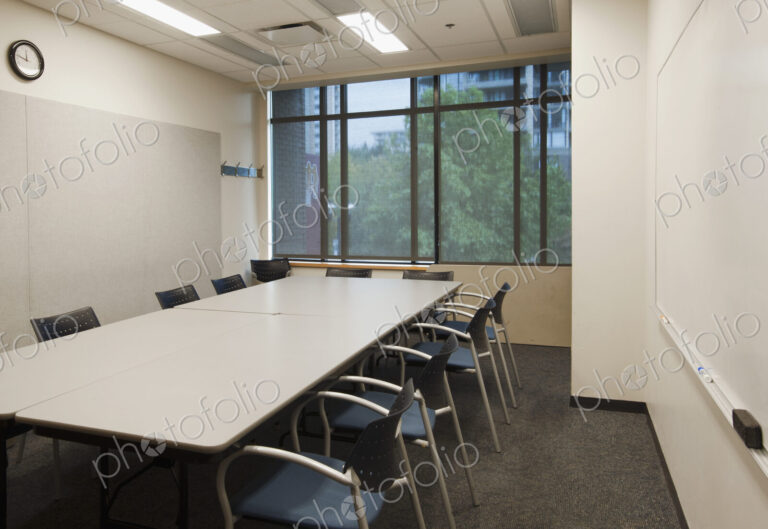 Small empty boardroom with a long rectangular table and chairs.