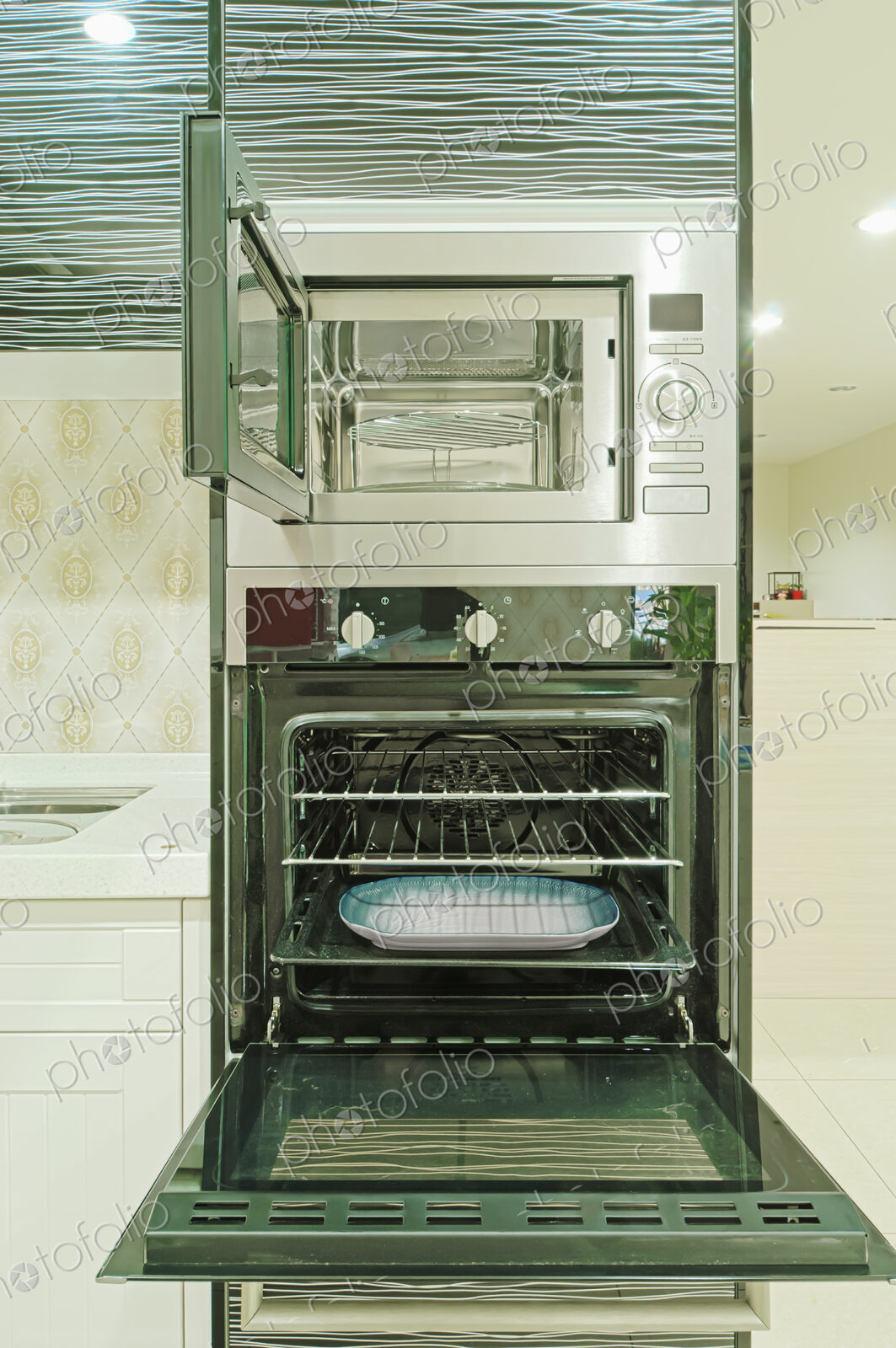 Small modern kitchen with fitted units and appliances and oven with an open door.
