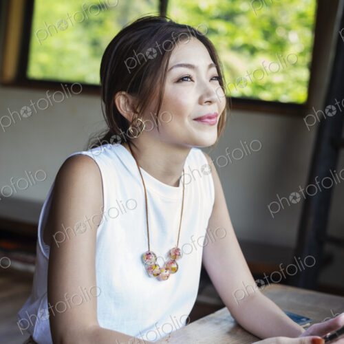 Smiling Japanese woman sitting at a table in a Japanese restaurant. Smiling Japanese woman sitting at a table in a Japanese restaurant.