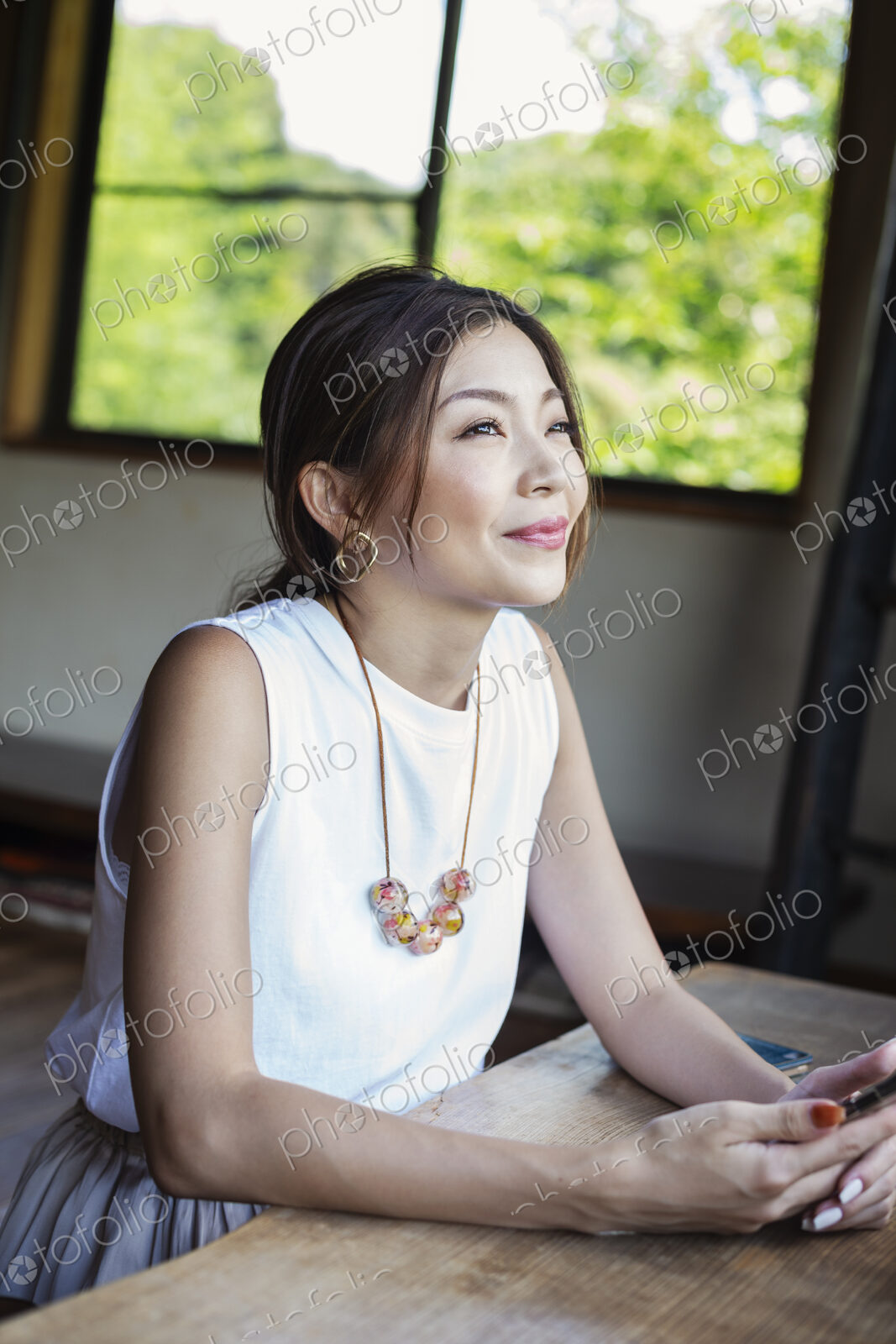 Smiling Japanese woman sitting at a table in a Japanese restaurant.