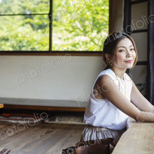 Smiling Japanese woman sitting at a table in a Japanese restaurant. Smiling Japanese woman sitting at a table in a Japanese restaurant.