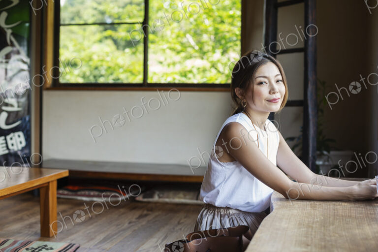 Smiling Japanese woman sitting at a table in a Japanese restaurant.