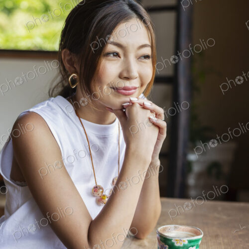 Smiling Japanese woman sitting at table in Japanese restaurant. Smiling Japanese woman sitting at table in Japanese restaurant.