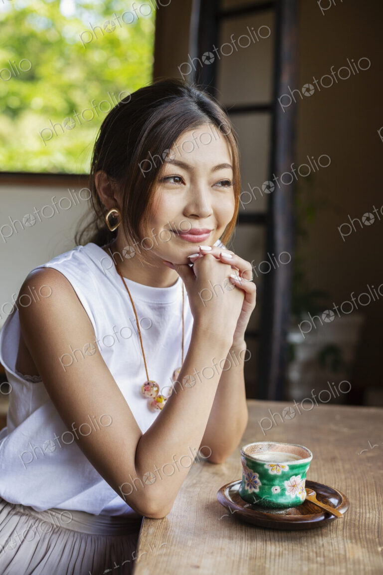 Smiling Japanese woman sitting at table in Japanese restaurant.